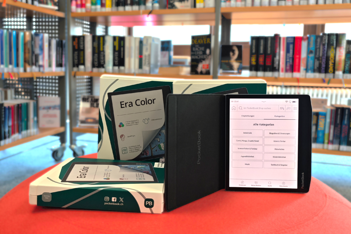 3 e-Reader der Firma Pocketbook auf Hocker vor Buchregal