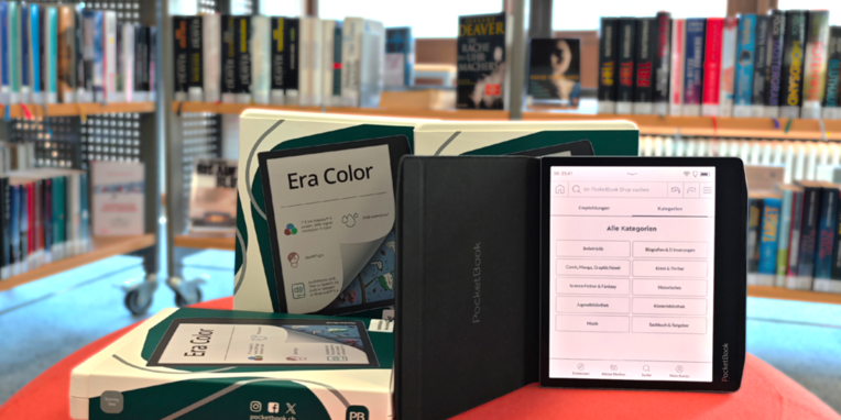 3 e-Reader der Firma Pocketbook auf Hocker vor Buchregal