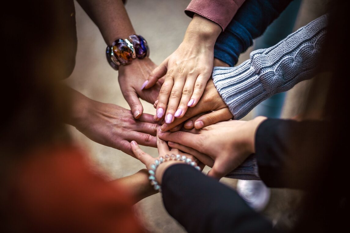 mehrere Hände übereinander Symbolisch für Teamwork, Netzwerk