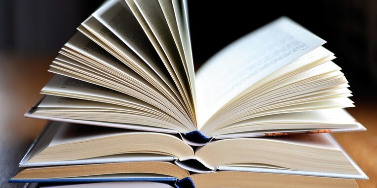 mehrere aufgeschlagene Bücher übereinander liegend