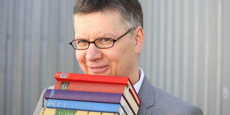Stephan Schäfer mit einem Stapel Bücher