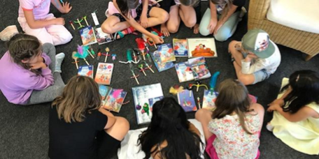 Kinder vor Büchern auf dem Boden