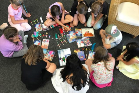 Kinder vor Büchern auf dem Boden