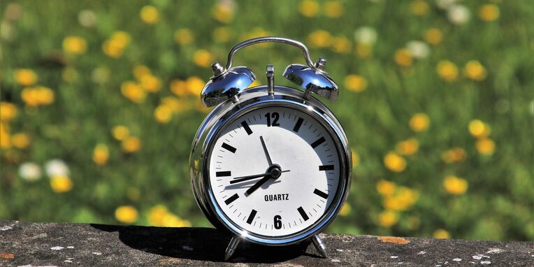Uhr mit sommerlichem Hintergrund