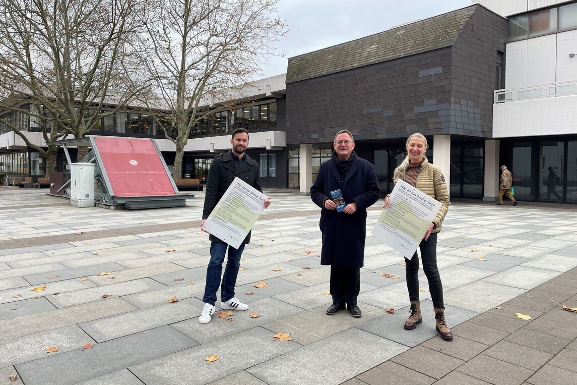Bürgermeister Dirk Gene Hagelstein, Christopher George und Dr. Bettina Stuckard vor der Hugenottenhalle