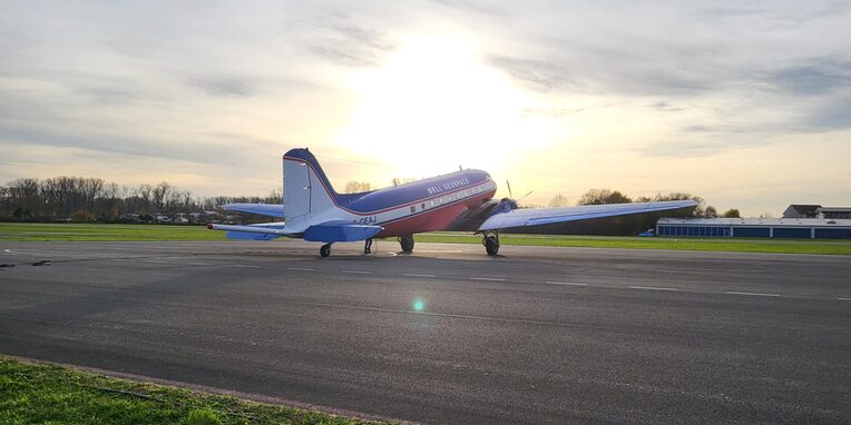 Ein Messflugzeug auf einer Start- und Landebahn im Abendlicht mit untergehender Sonne im Hintergrund