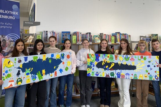 Die Lesescouts des Goethe-Gymnasiums präsentieren ihre bunten Leinwände mit Monstermotiven in der Kinderbibliothek