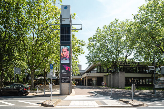 Blick auf die Hugenottenhalle und Stadtbibliothek mit der digitalen Infosäule im Vordergrund