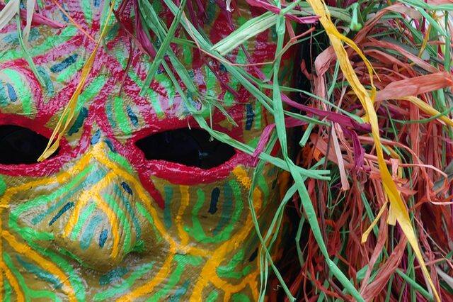 Bunte Faschingsmaske mit buntem Kopfschmuck mit wenigen gelben Zähnen