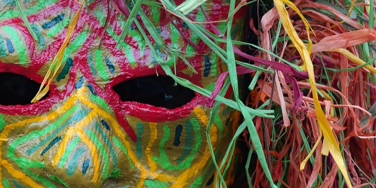 Bunte Faschingsmaske mit buntem Kopfschmuck mit wenigen gelben Zähnen