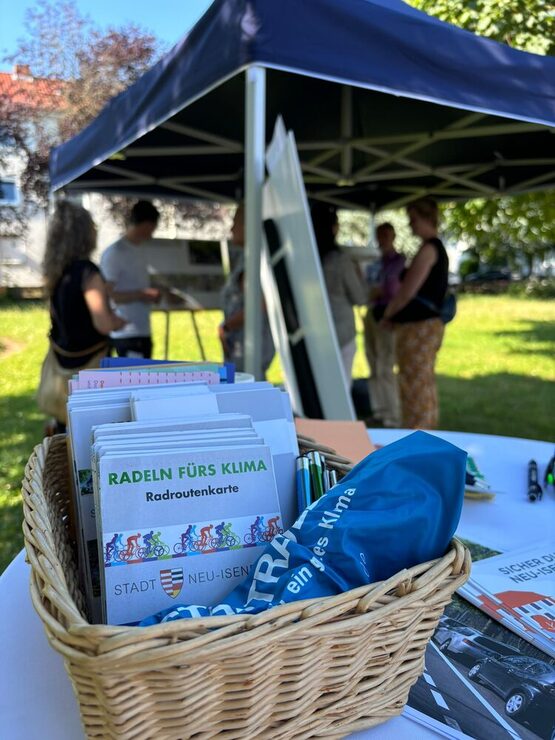 Ein Korb mit Informationsmaterial an einem Infostand (im Hintergrund) bei der Veranstaltung im Juni 2025