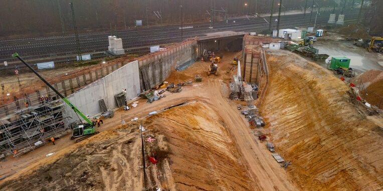 Tunneldurchstich Regionaltangente West am Kreuzungsbauwerk Neu-Isenburg, Blick auf den Tunnel mit Sandhügeln, Baugeräten und Arbeitern