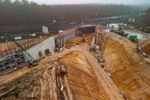 Tunneldurchstich Regionaltangente West am Kreuzungsbauwerk Neu-Isenburg, Blick auf den Tunnel mit Sandhügeln, Baugeräten und Arbeitern