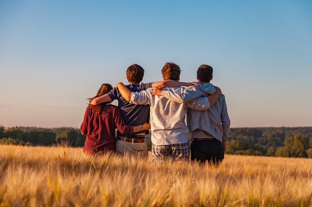 Eine Gruppe sitzender junger Leute mit Blick in die Ferne