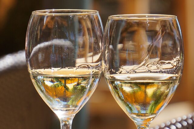 2 Weingläser halb gefüllt mit Wein auf einem Holztisch
