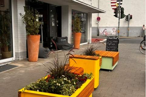 orangefarbene Sitzmöglichkeit auf der Frankfurter Straße mit Pflanzgefäßen