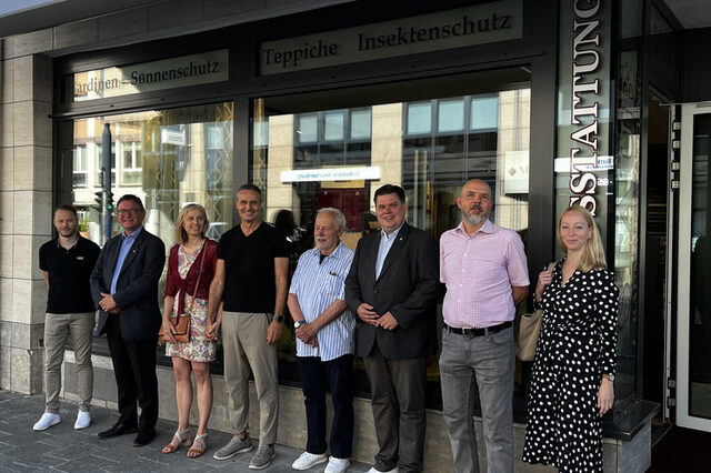 Akteure des Anreizprogramms vor dem Geschäft Raumausstattung Volk