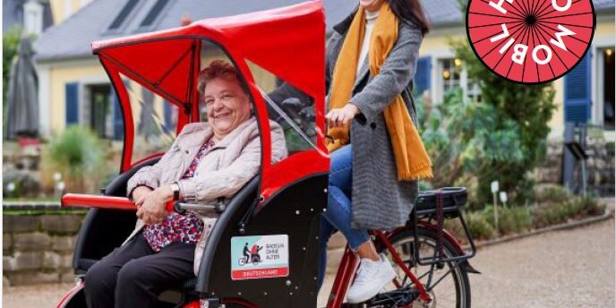 Ein rotes Rickscha Hugo Mobil mit 2 Frauen im Einsatz