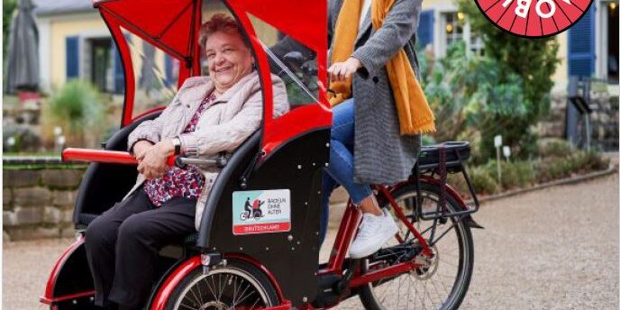 Ein rotes Rickscha Hugo Mobil mit 2 Frauen im Einsatz