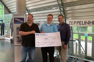 Vorsitzende des Vereins für Zeppelin-Luftschifffahrt e.V., Jens Schenkenberger,   Vorstandsmitgliedern Christian Beck (links) und Michael Blatz (rechts) bei der Scheckübergabe