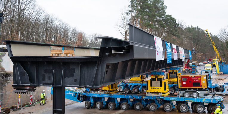 In Bewegung: Ein Self Propelled Modular Trailer (SPMT) fährt die 250 Tonnen schwere Brücke in Richtung Einbauposition.