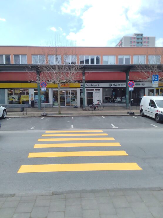 Gelber Zebrastreifen vor Ladengeschäft