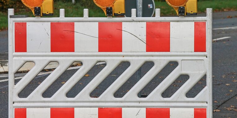 Straßenabsperrung mit orangefarbenen Warnlichter