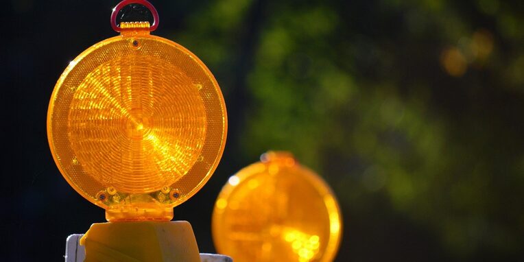 gelbe Warnlichter die auf Baustellenarbeiten hinweisen