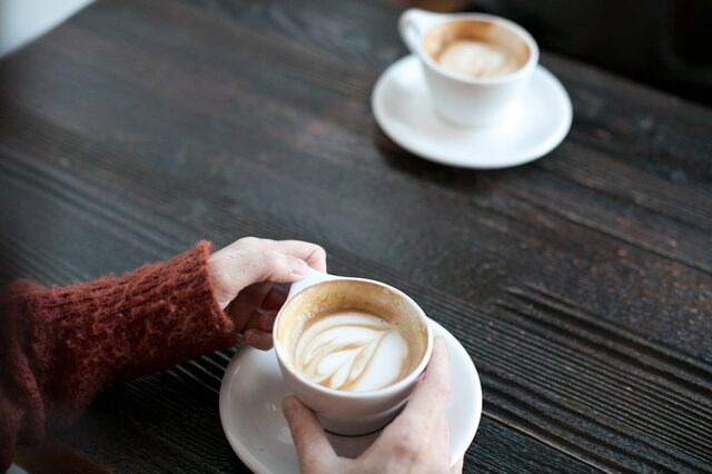 Kaffeetasse steht vor einer Frau