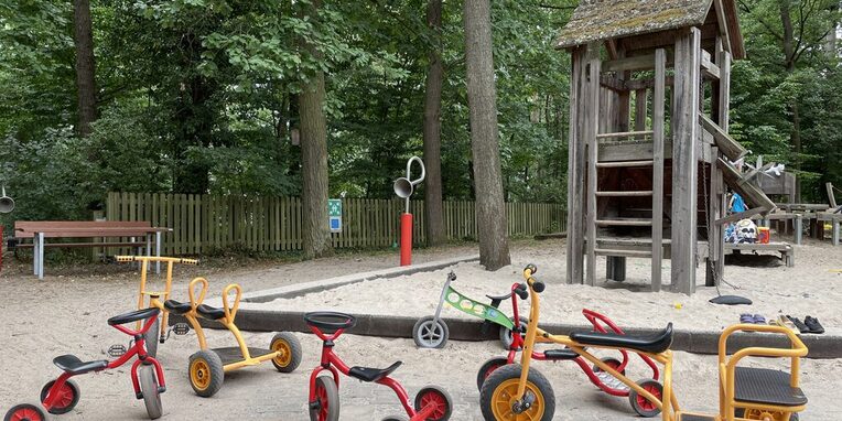 Außenbereich der KITA in Zeppelinheim mit ihrem "kleinen Fuhrpark"