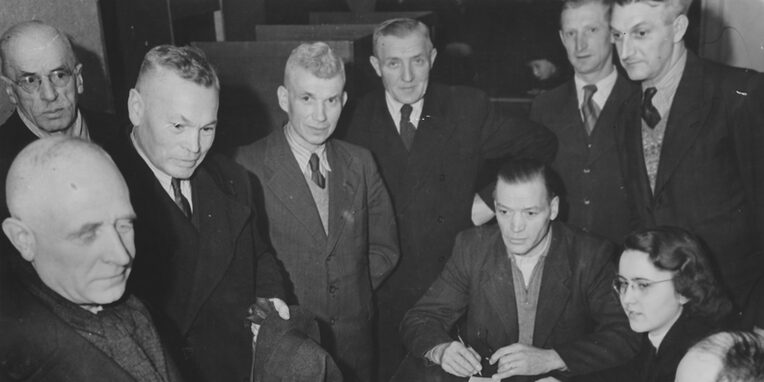 Das Bild zeigt die Stimmabgabe des Bürgermeisters Wilhelm Arnoul bei der Gemeinderatswahl am 27. Januar 1946 im Wahllokal in der Westendhalle. Zu sehen sind daneben v.l.n.r.: Georg Koser, Adolf Bauer, Philipp Wiemer, Adam Ebner, August Geiß (sitzend), Dr. Juliane Girardi-Vogt, Heinrich Zimbrich, Unbekannt, Fotograf: Paul Zehner, Offenbach]. Quelle: Stadtarchiv NI F 2.3 Nr. 49 Bld. 1